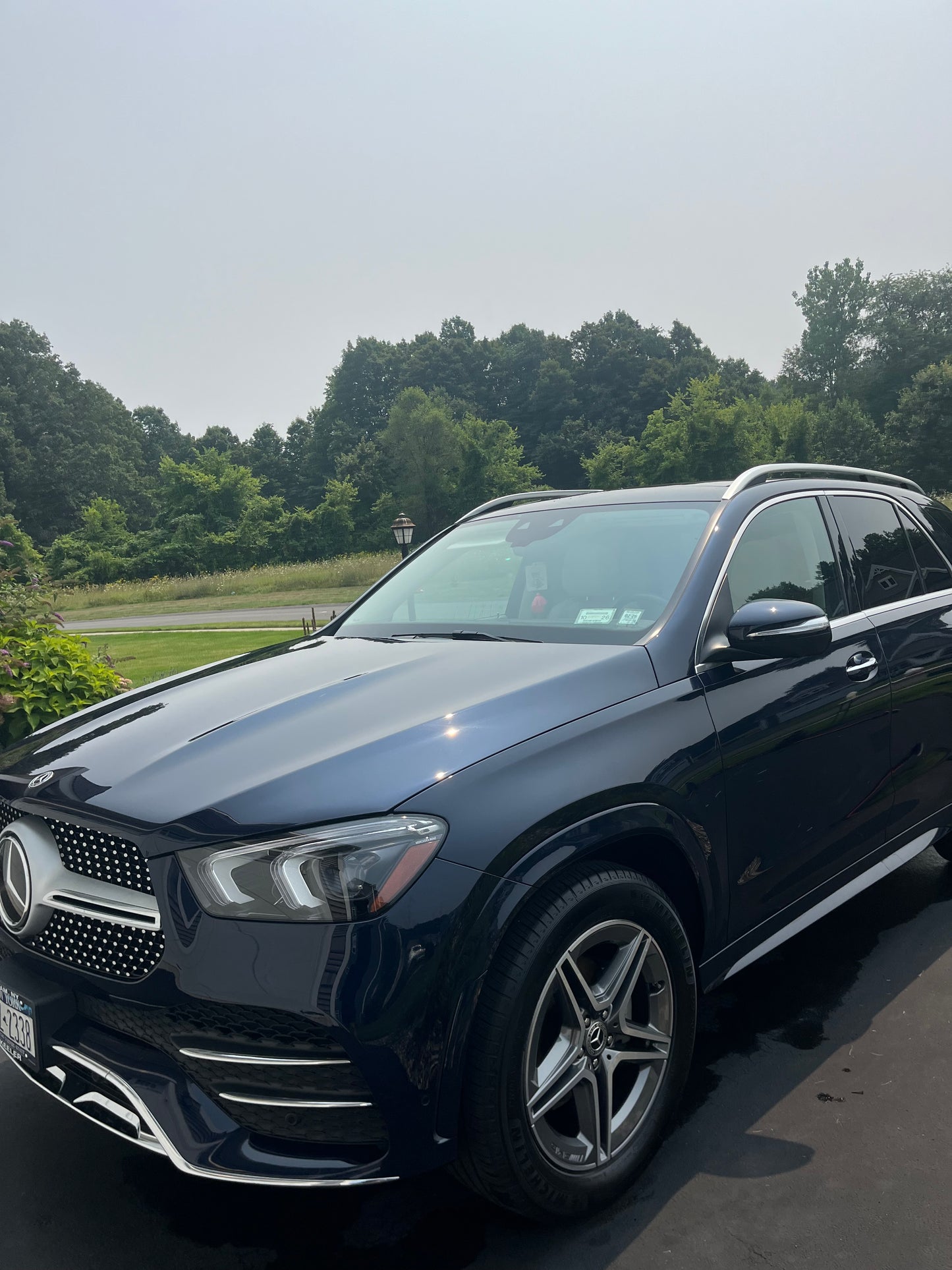 Navy SUV parked outdoors with trees in the background